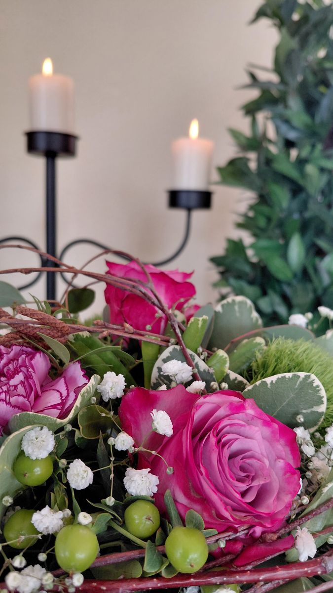Blumengesteck mit pinkfarbenen Rosen und Kerzen