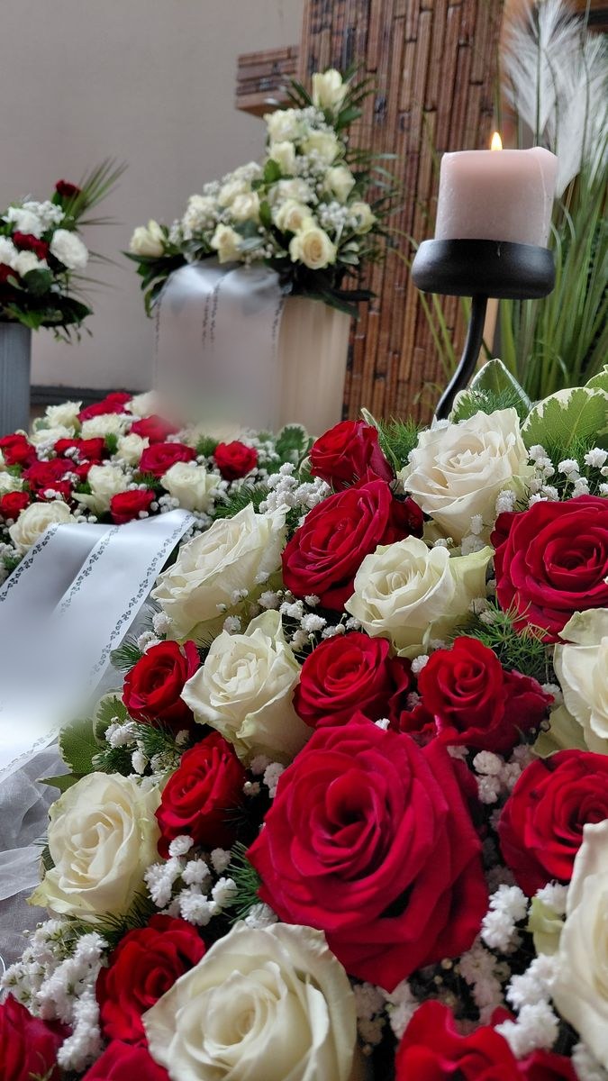 Sargschmuck aus roten und weißen Rosen